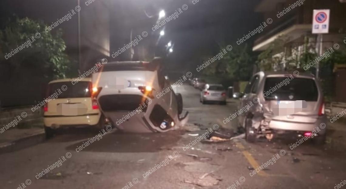Perde il controllo dell'auto e si ribalta colpendo i veicoli in sosta