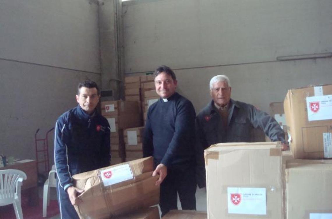 I volontari dell'ordine di Malta distribuiscono  vestiti ai bisognosi