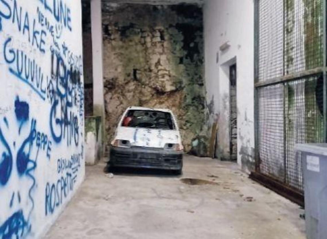 Scritte sui muri, rifiuti e una vecchia auto abbandonata: degrado nel centro storico