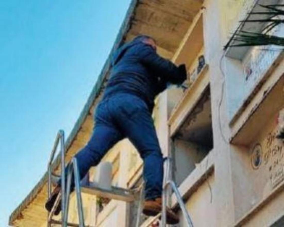 Costretto ad arrampicarsi tra le lapidi per deporre un fiore: la foto diventa virale
