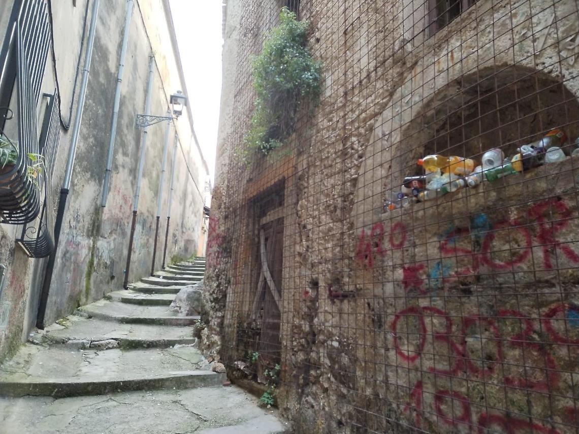 Bottiglie di vetro e cartacce nei vicoli del centro storico