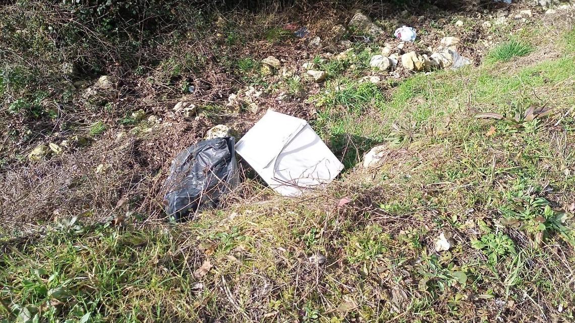 Sedie e rifiuti di plastica abbandonati sul letto del rio
