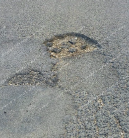 Una strada colabrodo. Asfalto danneggiato e buche