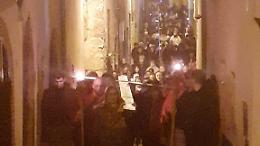 Bestemmiano mentre passa la processione con il Cristo morto